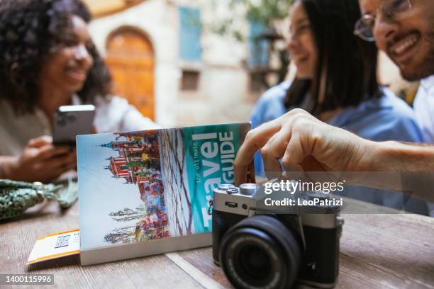 three friends on vacation taking a break in a bar - guidebook stock pictures, royalty-free photos & images
