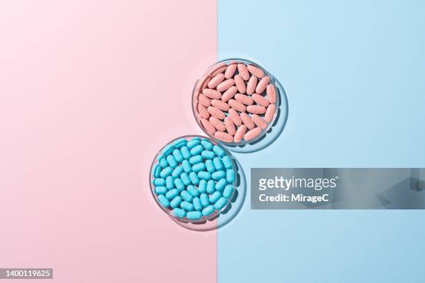blue and pink pills and capsules in petri dishes - space capsule fotografías e imágenes de stock
