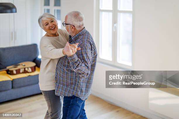 senior couple dancing together at home - swaying stock pictures, royalty-free photos & images