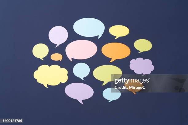 a group of colorful speech bubbles on purple - speech bubble fotografías e imágenes de stock