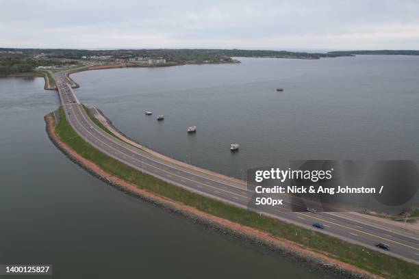 high angle view of bridge over river against sky,prince edward island,canada - polder barrage photos et images de collection