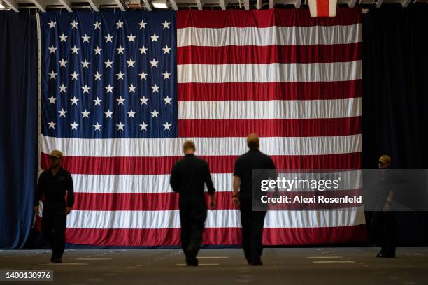 Navy sailors walk near an American flag on the USS Bataan on Memorial Day on May 30, 2022 in New York City. The USS Bataan along with multiple other...