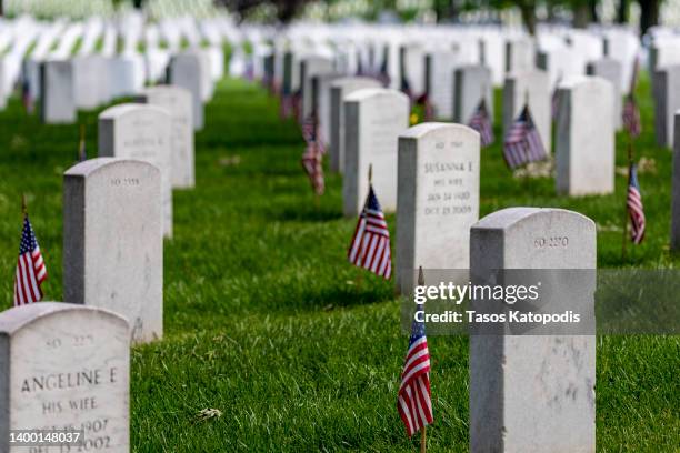 Headstones with American flags are seen at Arlington National Cemetery on May 30, 2022 in Arlington, Virginia. Memorial Day events are being held...