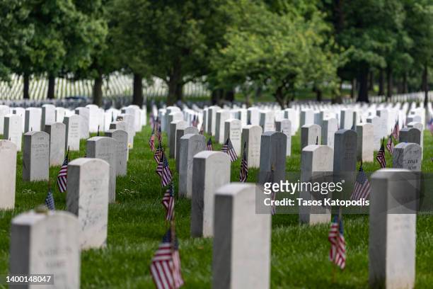 Headstones with American flags are seen at Arlington National Cemetery on May 30, 2022 in Arlington, Virginia. Memorial Day events are being held...