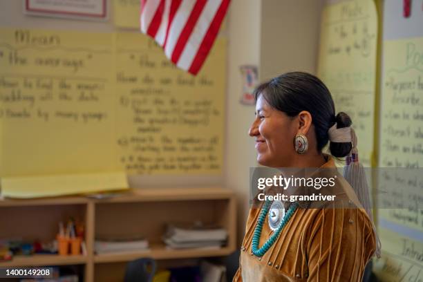 professora jovem sorridente na frente de sua sala de aula engajando e ensinando seus jovens alunos - reserva navajo - fotografias e filmes do acervo
