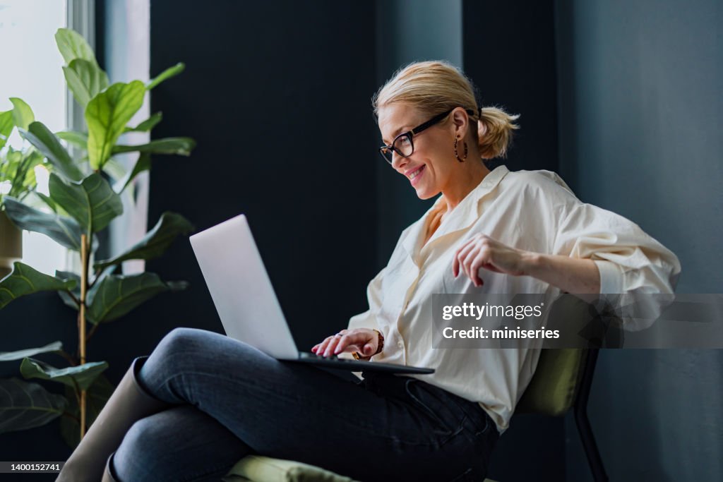 Happy Business Woman Using Laptop Computer In The Office