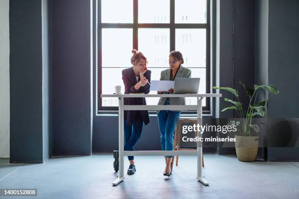 zwei geschäftsfrauen arbeiten gemeinsam an einem neuen projekt - ergonomie stock-fotos und bilder