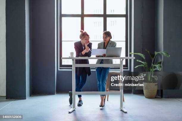 two business woman working together on a new project - business women looking at new office space stockfoto's en -beelden