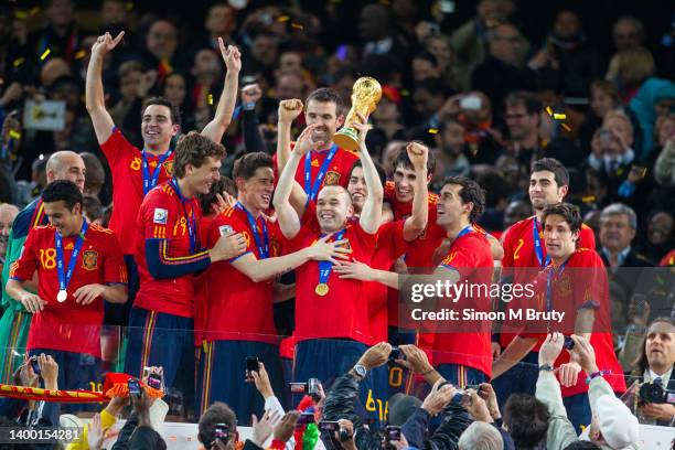 Andreas Iniesta of Spain and the goal scorer celebrates with the trophy and and the Spanish team after victory in the World Cup Final match between...