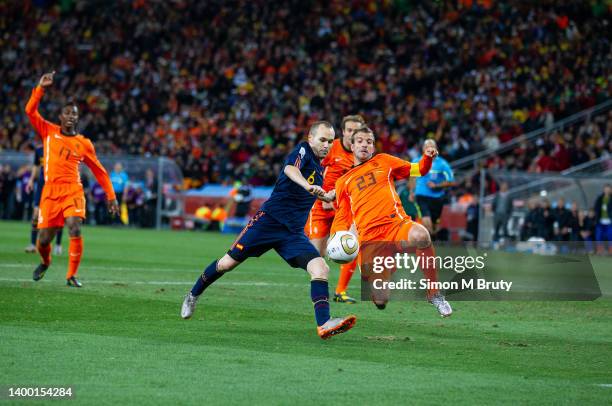 Andres Iniesta of Spain scores the winning goal despite the attention of Rafael Van Der Vaart of Netherlands during the World Cup Final match between...