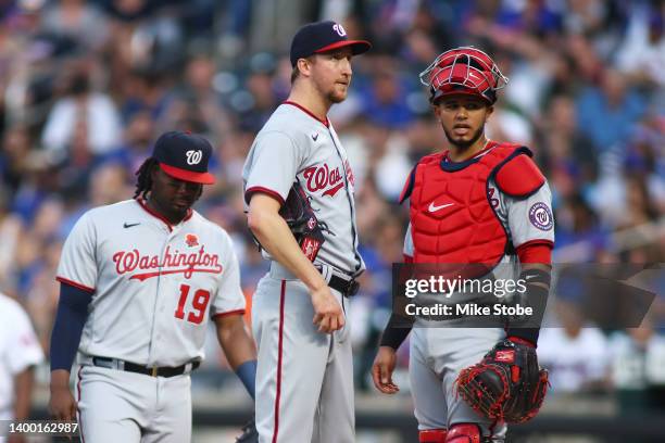 Erick Fedde of the Washington Nationals reacts in the first inning as Josh Bell and Keibert Ruiz look on against the New York Mets at Citi Field on...
