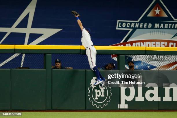 Eli White of the Texas Rangers catches a fly ball at the wall off the bat of Ji-Man Choi of the Tampa Bay Rays in the first inning at Globe Life...