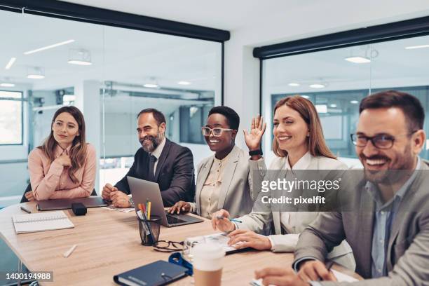 young businesswoman raising her hand during a conference - panelist stock pictures, royalty-free photos & images