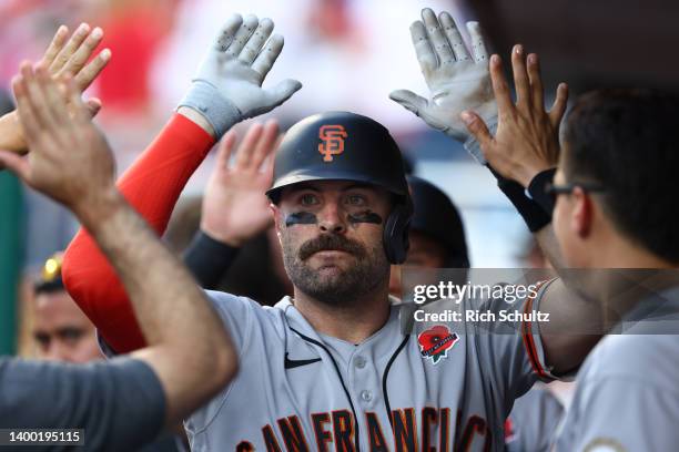 Curt Casali of the San Francisco Giants is congratulated by teammates after he hit a two-run home run in the 10th inning against the Philadelphia...