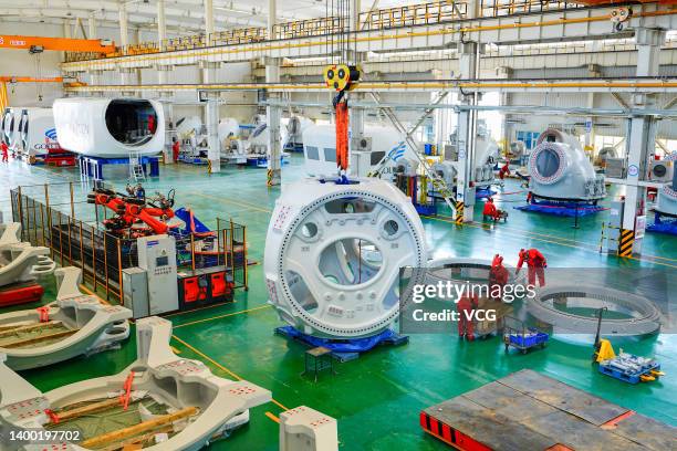 Employees work on the assembly line of wind turbine at a branch of Xinjiang Goldwind Science & Technology Co., Ltd on May 30, 2022 in Hami, Xinjiang...