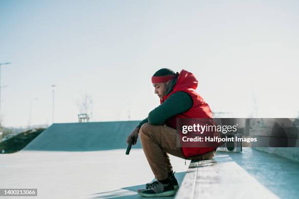 young boy sitting in skate park with gun - gun control stock pictures, royalty-free photos & images
