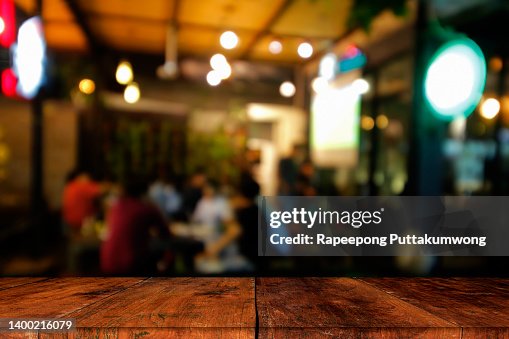 Wood table top with blur of lighting in night cafe. Celebration concept Wood table top with blur of lighting in night cafe. Celebration concept