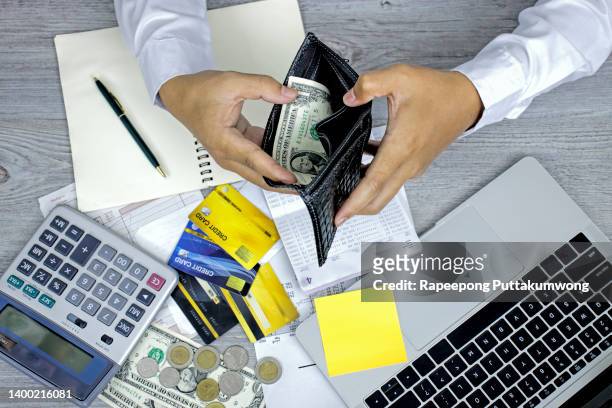 man hand opening wallet, debt expense bills monthly and credit card at the table in home office , managing payroll,money risk financial concept - payroll stock pictures, royalty-free photos & images