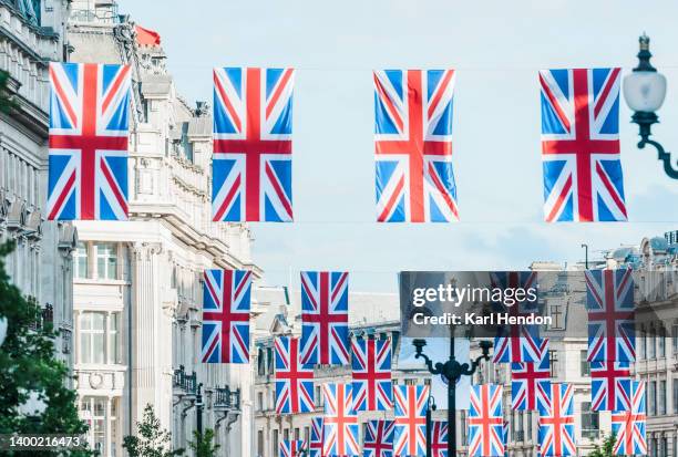 a surface level view of regent street in london - union jack flags - realeza británica fotografías e imágenes de stock