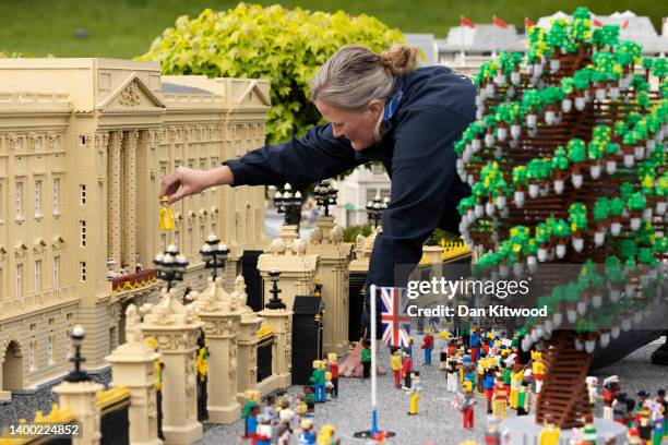 Model maker Paula Young poses as she places a model of the Queen during a Queen's Platinum Jubilee photocall at Legoland Windsor on May 31, 2022 in...