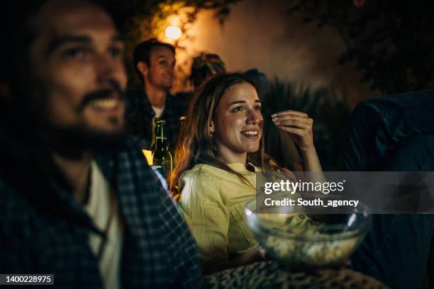 friends watching movie on the video projector in the backyard garden - outdoor cinema stock pictures, royalty-free photos & images