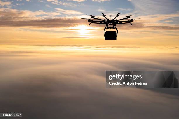 delivery drone on the background of the sunset in the clouds. delivery concept - drone parcel stock pictures, royalty-free photos & images