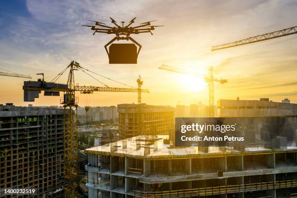 industrial drone at a construction site at sunset. construction cranes - strong foundations stock pictures, royalty-free photos & images