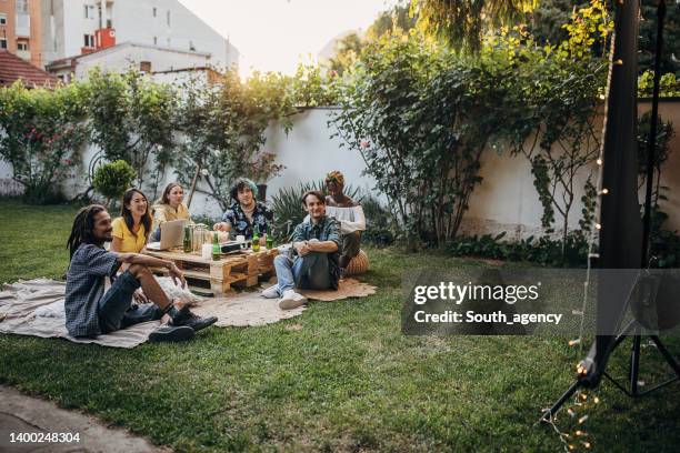 friends watching movie on the video projector in the backyard garden - backyard movie stock pictures, royalty-free photos & images