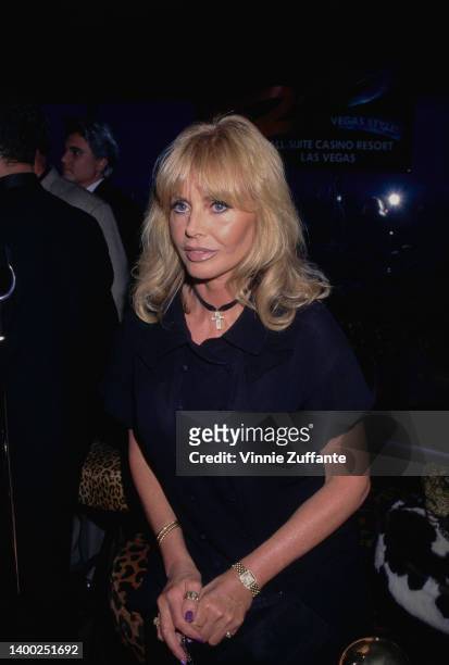 Swedish actress and singer Britt Ekland, wearing a black outfit with a crucifix pendant hanging from a choker, attends a press conference ahead of...