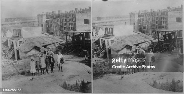 Stereoscopic image showing a group of people posing among the slums of 'Mackerelville,' the area that later became the East Village in the borough of...