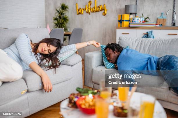 two hangover friends waking up after a birthday party - after party living room stock pictures, royalty-free photos & images