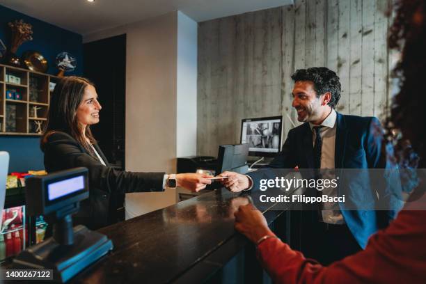 un paio di uomini d'affari effettuano il check-in presso la hall dell'hotel - booking hotel foto e immagini stock