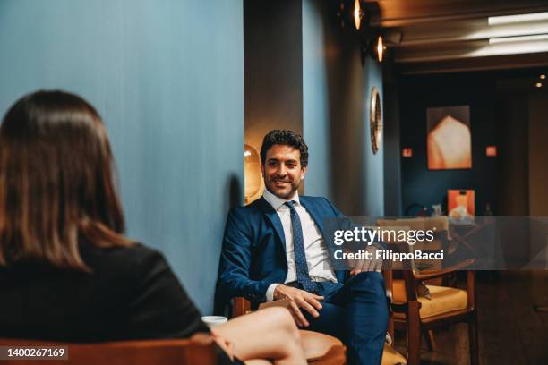 uomini d'affari stanno parlando insieme nella hall di un hotel - lobby foto e immagini stock