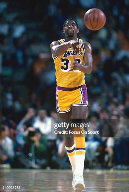 Earvin Magic Johnson of the Los Angeles Lakers passes the ball up court during an NBA basketball game circa 1983 at The Forum in Inglewood,...