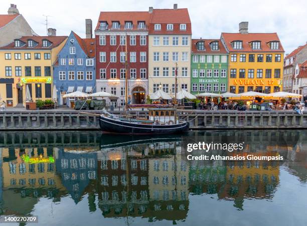 Colorful old houses in Nyhavn waterfront on May 29, 2022 in Copenhagen, Denmark. Nyhavn is a 17th-century waterfront, canal and entertainment...