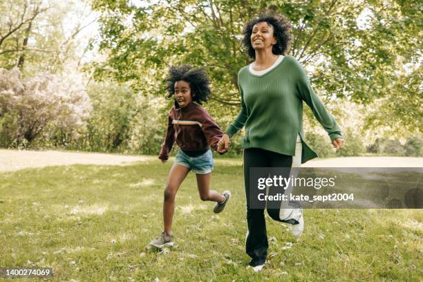 mother and daughter running in the park - running toronto stock pictures, royalty-free photos & images