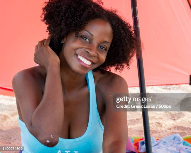 portrait of beautiful mature woman at beach under umbrella,sebastian inlet state park,united states,usa - 500px plus stockfoto's en -beelden