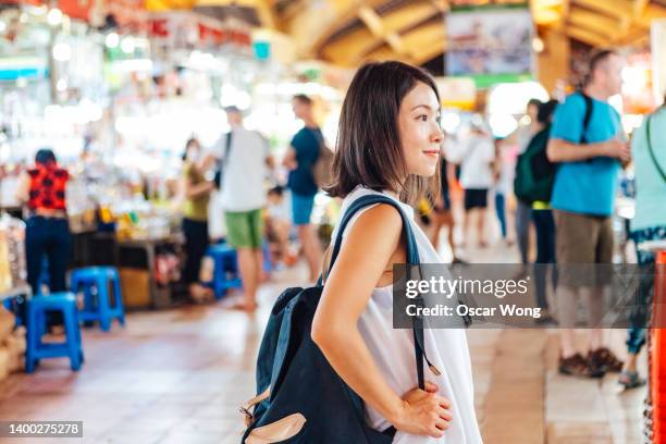 young female traveler walking in local street food market at ho chi minh city, vietnam - vietnamese cuisine stock pictures, royalty-free photos & images