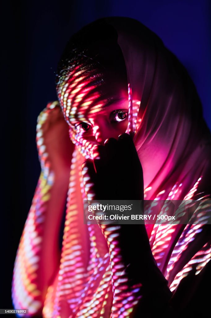Girl light painting,Woman with illuminated string lights in darkroom