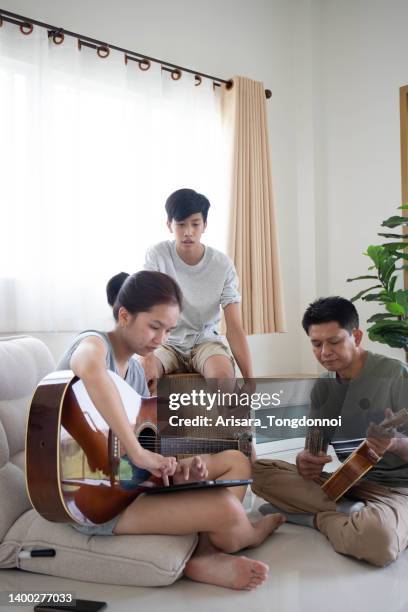 the family was enjoying playing music and singing. - entertainment occupation stock pictures, royalty-free photos & images