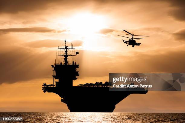 aircraft carrier at sunset in the sea - army helicopter stock pictures, royalty-free photos & images