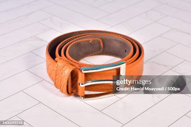 high angle view of belt on tiled floor - ceinture en cuir photos et images de collection