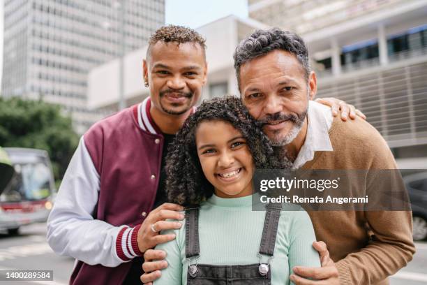 pareja gay con niña adoptada en la avenida paulista en sao paulo, brasil - gay fotografías e imágenes de stock