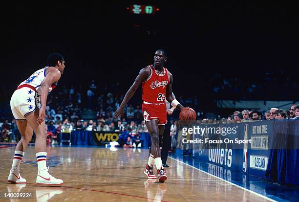 Michael Jordan of the Chicago Bulls dribbles the ball up court guarded by Jeff Malone of the Washington Bullets during an NBA basketball game circa...