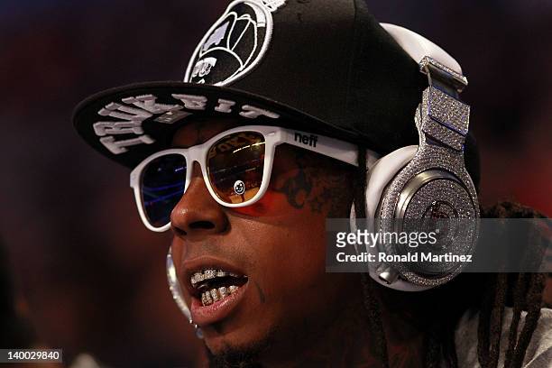 Hip-hop artists Lil' Wayne, wearing diamond studded beats headphones by Dr. Dre sits courtside during the 2012 NBA All-Star Game at the Amway Center...
