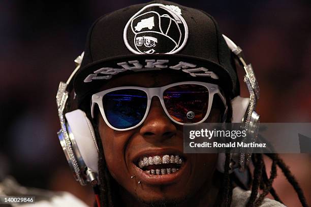 Hip-hop artists Lil' Wayne, wearing diamond studded beats headphones by Dr. Dre sits courtside during the 2012 NBA All-Star Game at the Amway Center...