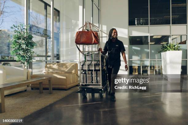 hotel lobby with employees and guests - bell boy stock pictures, royalty-free photos & images