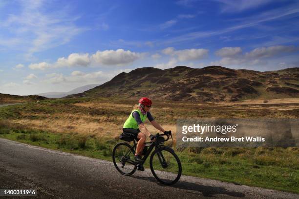 solo female cyclist takes the road less travelled - dumfries and galloway stock pictures, royalty-free photos & images