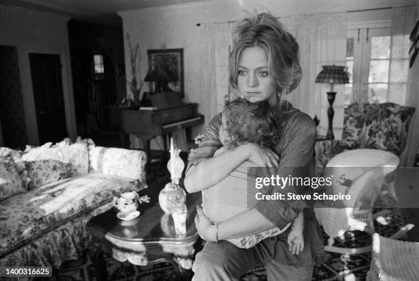 View of American actress Goldie Hawn as she holds her son Oliver, circa 1977.