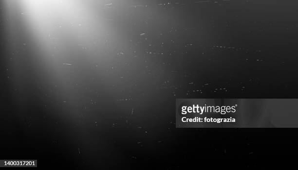 scratches and dust on black background with light rays - light beams stock-fotos und bilder